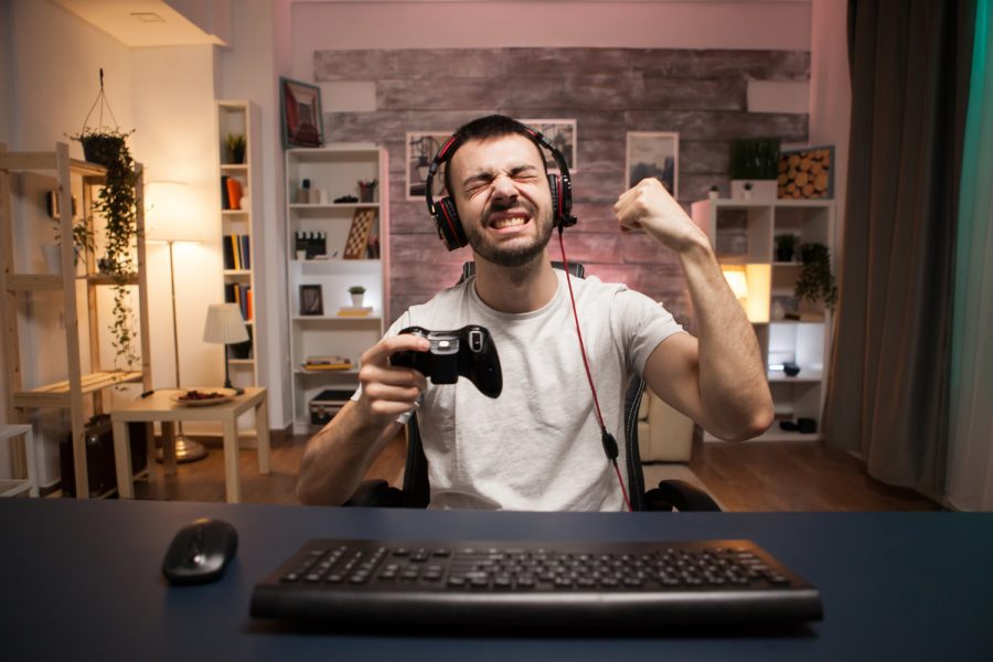 pov-happy-young-man-celebrating-his-victory-online-shooter-game-using-wireless-controller