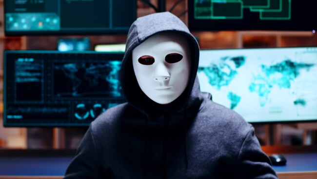 zoom-shot-cyber-criminal-wearing-white-mask-looking-camera