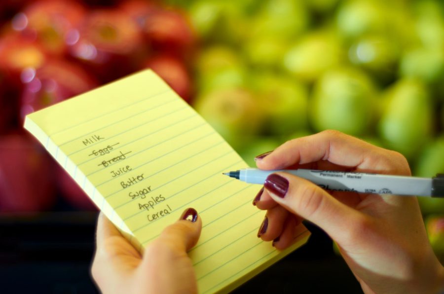 i-love-making-lists-cropped-image-womans-hand-holding-shopping-list