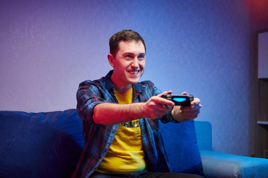 portrait-crazy-playful-gamer-boy-enjoying-playing-video-games-indoors-sitting-sofa-holding-console-gamepad-hands-resting-home-have-great-weekend