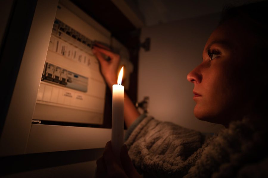 woman-checking-fuse-box-home-during-power-outage-blackout-no-electricity-concept