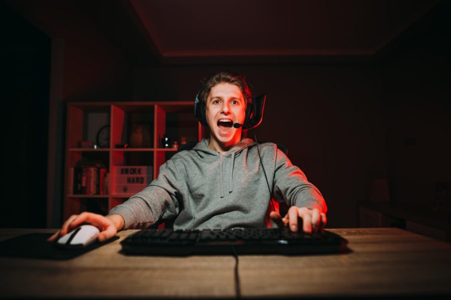 young-man-headset-playing-video-games-with-smile-his-face-room-with-red-interior
